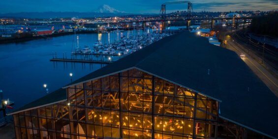 View of a boathouse in downtown Tacoma at dusk with Mt. Rainier in the distance