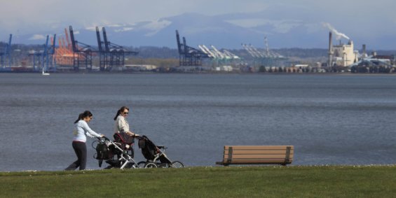 Two women push strollers along a bike path in the Port of Tacoma